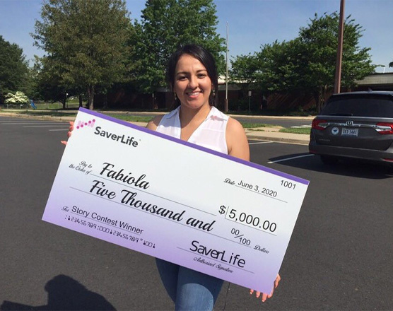 A woman holding her SaverLife check